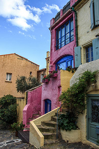 粉红色房子蓝色门在一个乡村里背景图片