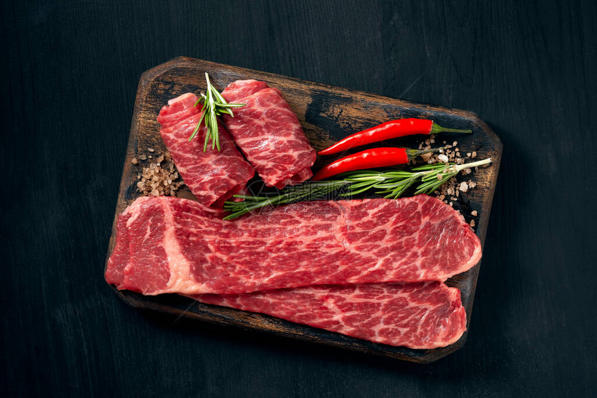 在黑暗背景的木板上烧烤时粗大理石牛肉黑安格斯片块肉类为Sukiya图片