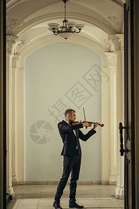 才华横溢的专业白人男小提琴手在大厅里演奏图片