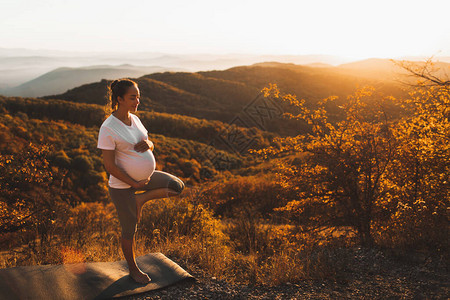 孕妇在日落时在山上户外做瑜伽图片