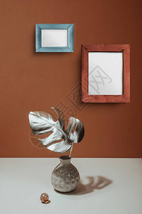 在陶土墙背景的花瓶中的银叶龟背竹趋势艺术设计柔和的简约静物现代设计的图片