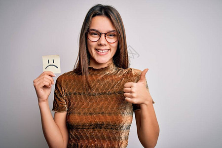 年轻漂亮的女孩带着悲伤的情绪表情在白色背景上拿着提醒图片