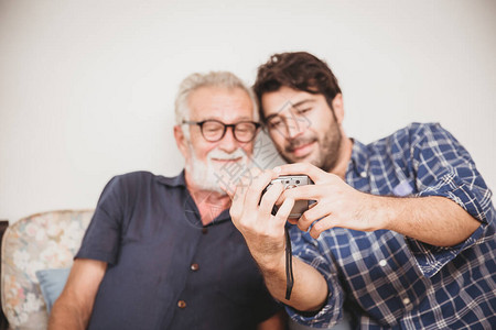年长者在重播数码摄影机的照片时图片