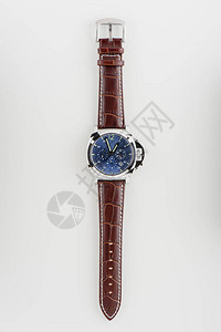 蓝色拨号的奢华时装手表和白色背景的棕鳄鱼谷图片