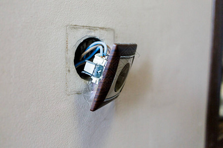 棕色破损的电源插座从墙上掉了下来插座从墙上撕下来违反用电安全图片
