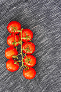 新鲜的红色西红柿织物上有小枝特写图片