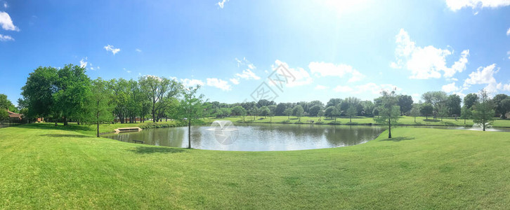 全景观望美国得克萨斯州达拉斯附近的大池塘和泉水喷泉的邻里公园背景图片