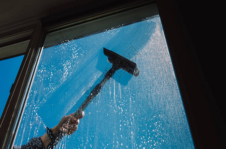 窗户清洁剂使用刮刀清洗窗户蓝天图片