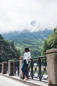 女孩站在河堤和山脚下图片