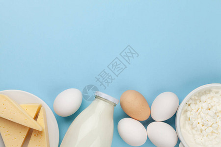 蓝色背景的乳制品牛奶小屋奶酪和鸡蛋顶视图图片