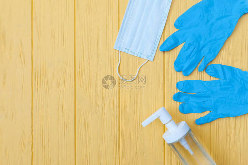 洗涤剂瓶呼吸面罩和黄色背景的手套图片