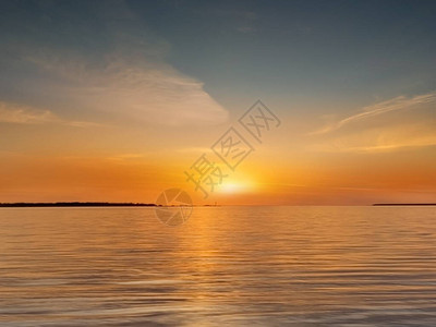 海上日落粉色蓝金黄色五颜六色的太阳光反射在海水波贝壳云彩上美丽的天空图片
