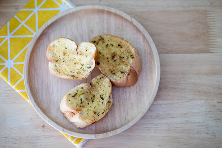 木板上有美味自制大蒜面包的木盘图片
