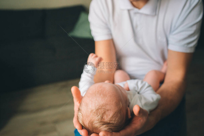 一个刚出生的婴儿的肖像父亲在她的怀里抱着一个孩子生命的第一年