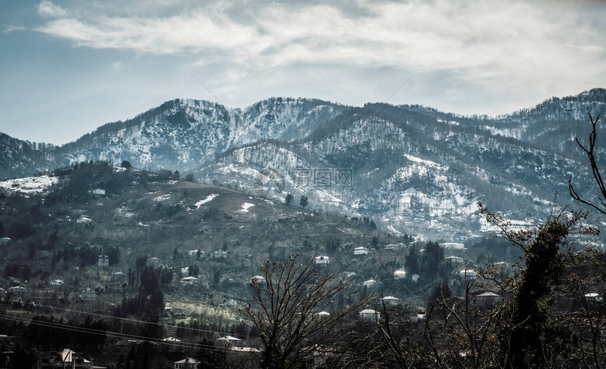 高加索山脚下的景色巴统市的区高处有雪在较低的山上是住宅楼地球有不同的颜色从高处看山的全图片