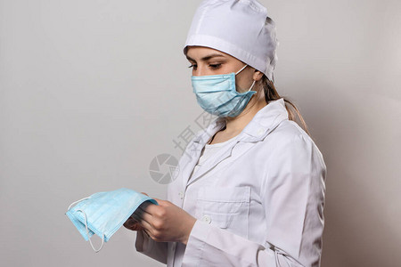 身着医疗制服和面罩的医生佩戴保护面罩头图片