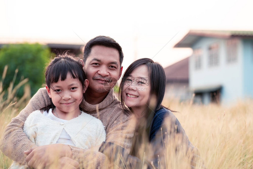 幸福的一家人坐在草地上擁抱图片