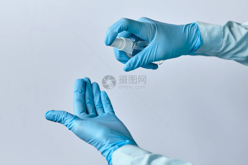 使用医疗手套中的消毒剂进行消毒的图片