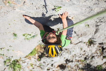 要加油啊一个戴头盔的男孩在山上攀岩极度爱好运动健壮的孩子要坚强起来岩石爬的安全也非常高啊背景