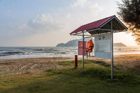 在沙滩背景泰语和英语背景的急救衣架上挂有警告标志图片
