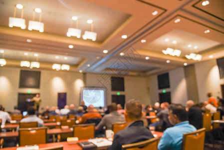 在美国德克萨斯州达拉斯的酒店会议室参加投资研讨会的多元化模糊不清带有大型投影仪监视器学生和扬声器的背景图片