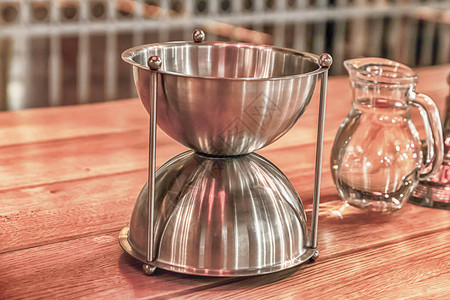 在一桶水旁边的玻璃杯状铁碗一种传统葡图片