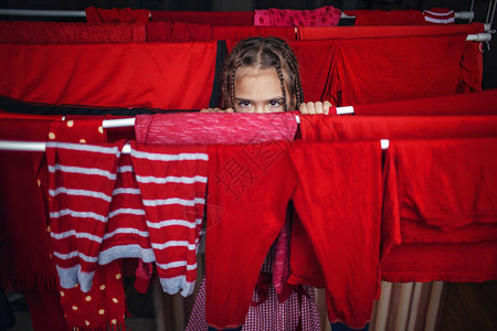 可爱的小女孩洗完后帮忙挂红衣服图片