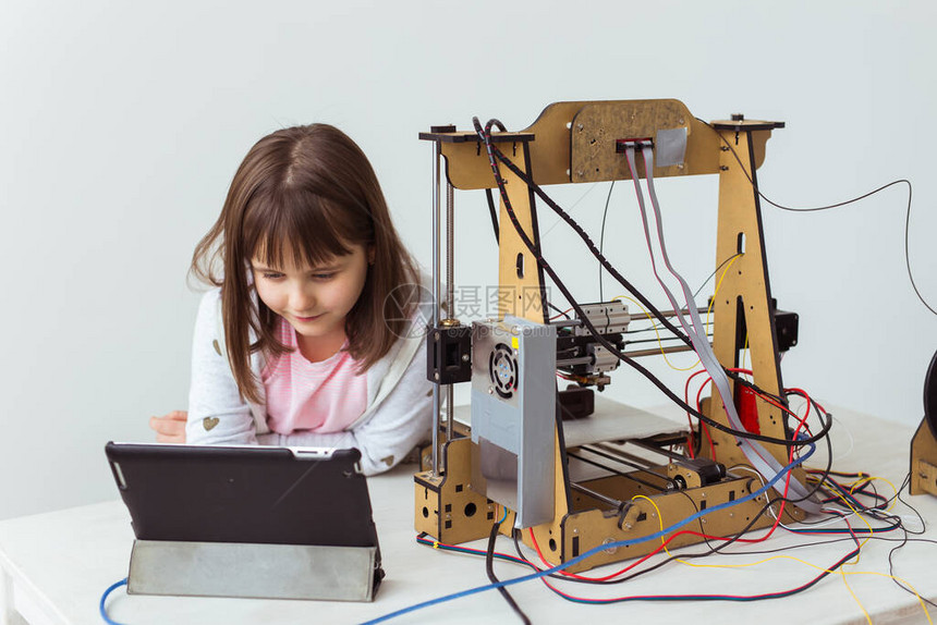 3D印有百叶窗的可爱女孩正在看她的3D打印机图片