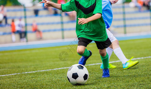 小男孩在踢足球比赛年轻球员在运动草地上踢足球快乐的孩子们在图片