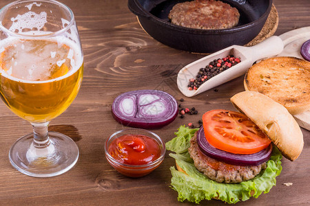 半杯啤酒配美味的自制汉堡图片