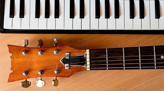 木制背景的音乐吉他和钢琴钥图片