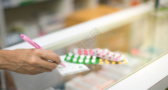 女药剂师准备药胶囊包药房卖给病人在药店保护对图片