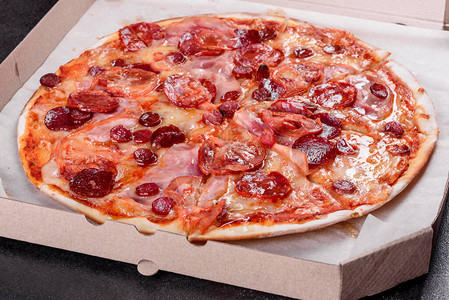 意大利辣香肠披萨配马苏里拉奶酪意大利腊肠西红柿胡椒和香料图片