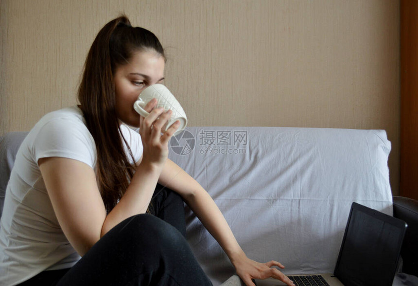 头发黑的年轻美女坐着笔记本电脑和咖啡图片