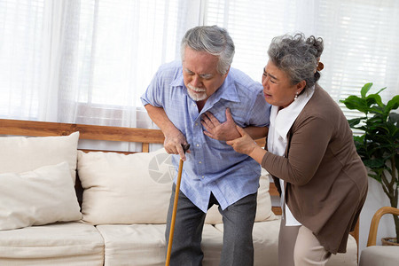 亚洲老人在客厅心痛由妻子照顾健康问题图片