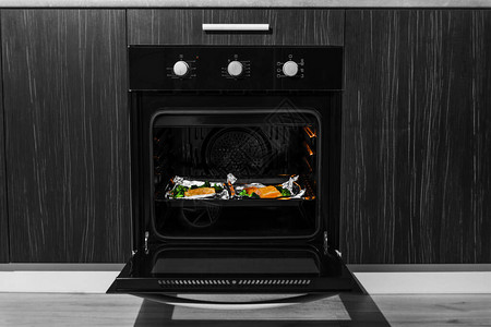 在厨房打开黑色内置对流烤箱烤箱鲑鱼图片