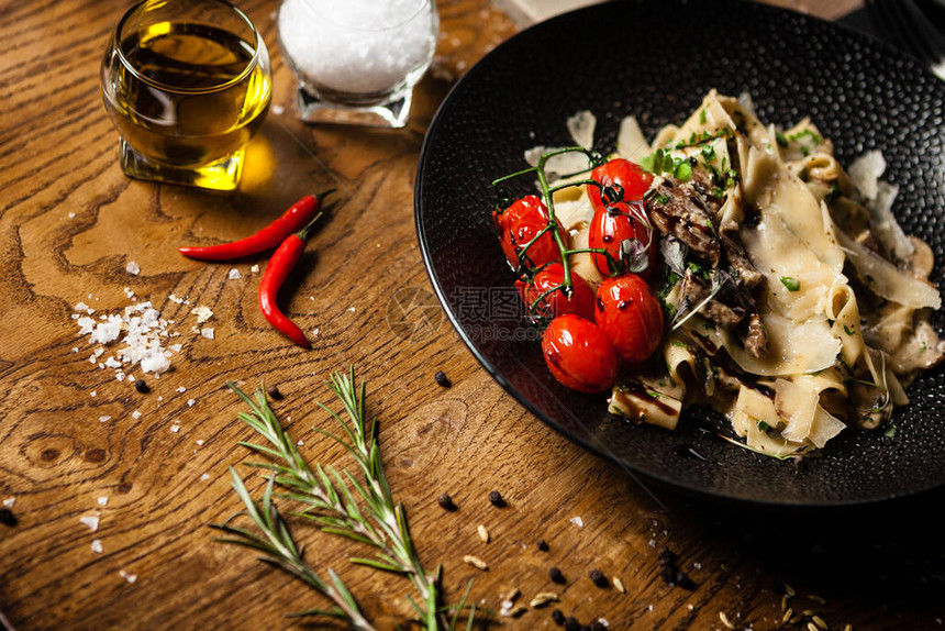 黑安格斯意大利面配牛肉香菇和帕尔马干酪在现代美食餐厅的餐桌上享用美味健康的地中海图片