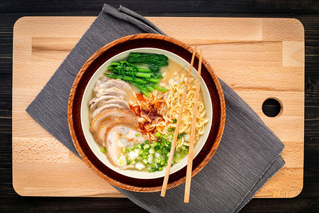 亚洲拉面猪肉骨汤和切菜板背景图片