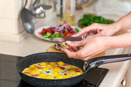 午餐早餐鹌鹑蛋在平底锅里煎女手在平图片