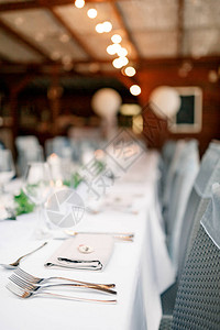 前景是白色桌布上的叉子桌子上的花环图片