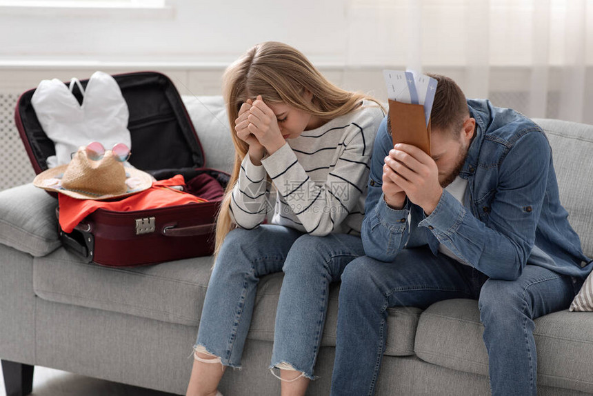 旅行限制家庭里坐在包装行李箱旁图片
