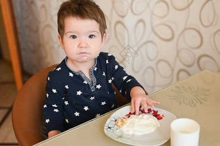 孩子坐在桌子上独自吃粥图片