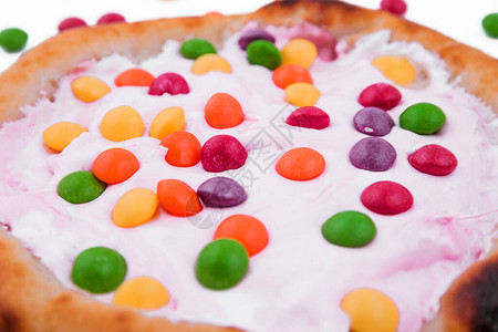 甜比萨配棉花糖酱和白色背景的彩色糖果水平照片图片