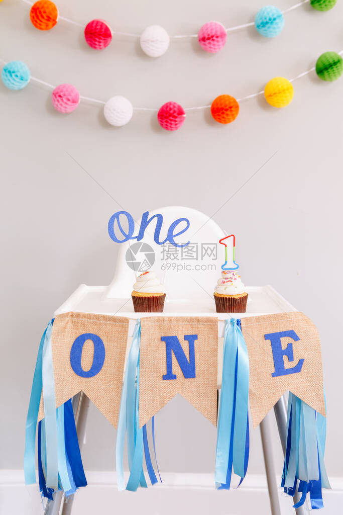生日庆祝的节日背景装饰字母在婴儿生日的小纸杯蛋糕中发短信给一根蜡烛背景上的花环装饰蛋图片