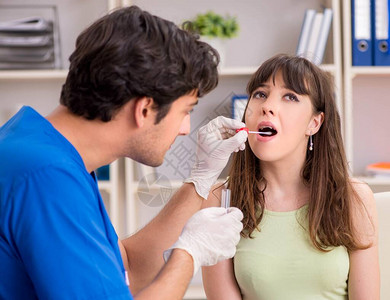 年轻女子拜访男医生牙医去除牙垢图片