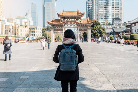 在金碧广场金马和玉鸡牌坊旅行的年轻女子旅行者图片