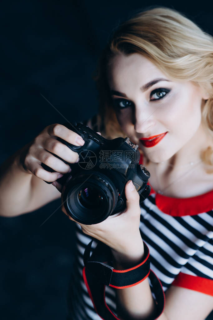 年轻漂亮的女孩摄影师在摄影棚里手拿着相机女工作是一种爱好软选择焦点图片