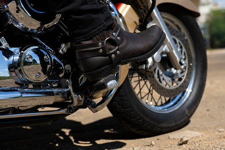 骑摩托车的骑自行车的人穿着皮革牛仔靴的腿底部视图图片