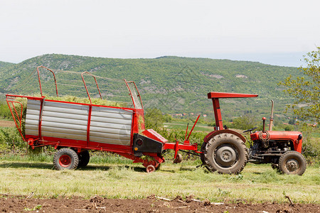 拖拉机与干草收集器在领域图片