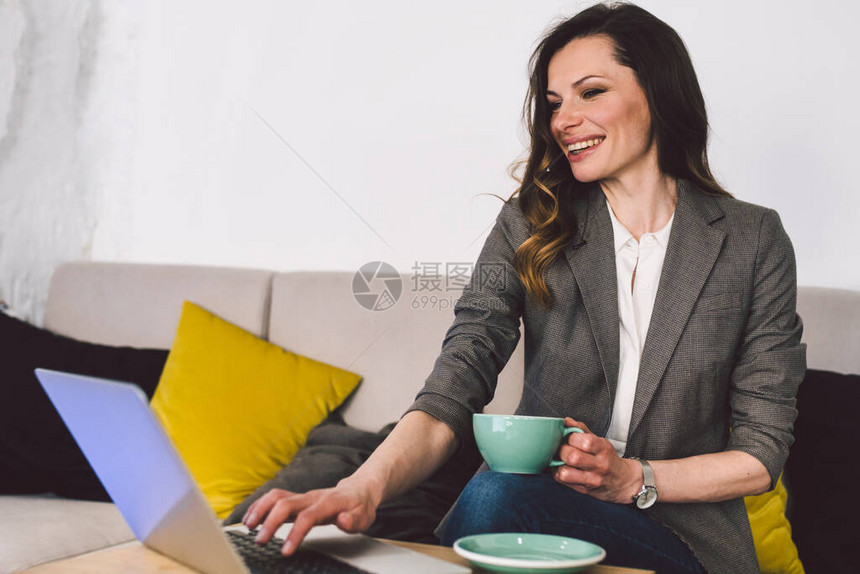 成功自信的中年女教师在上网课前喝杯咖啡图片